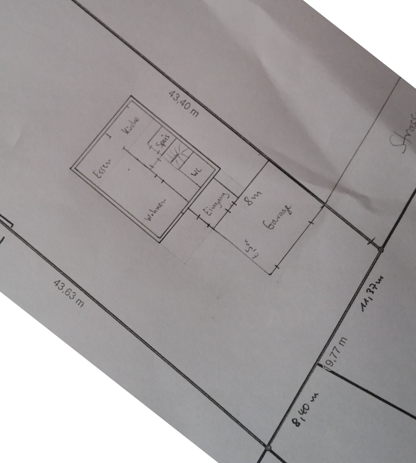 Grundrissplan eines Hauses mit Küche, Wohnzimmer, Essbereich, Flur und Bad