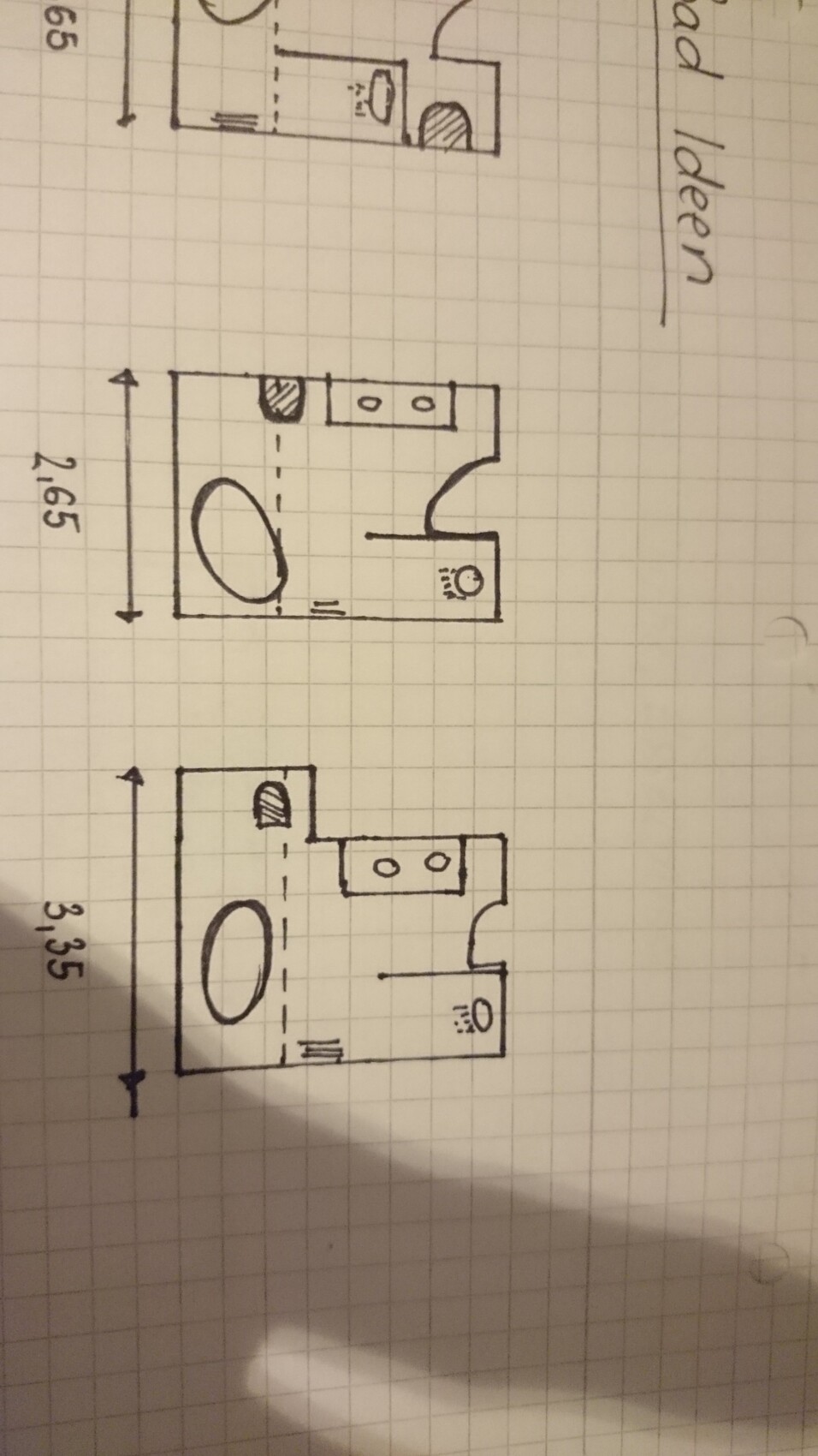 Skizzen eines Wohnungsgrundrisses mit Bad, Küche und Flur auf kariertem Papier.