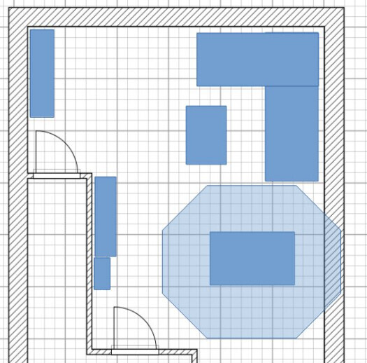 Grundriss eines Raums mit blauen Möbeln: L?Couch rechts, Tisch in Mitte, achteckiger Teppich.
