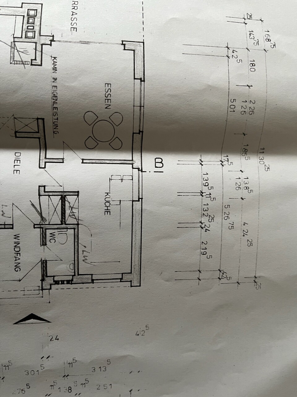 Grundriss einer Wohnung: Esszimmer mit rundem Tisch, 4 Stühle, Küche, Diele, WC.
