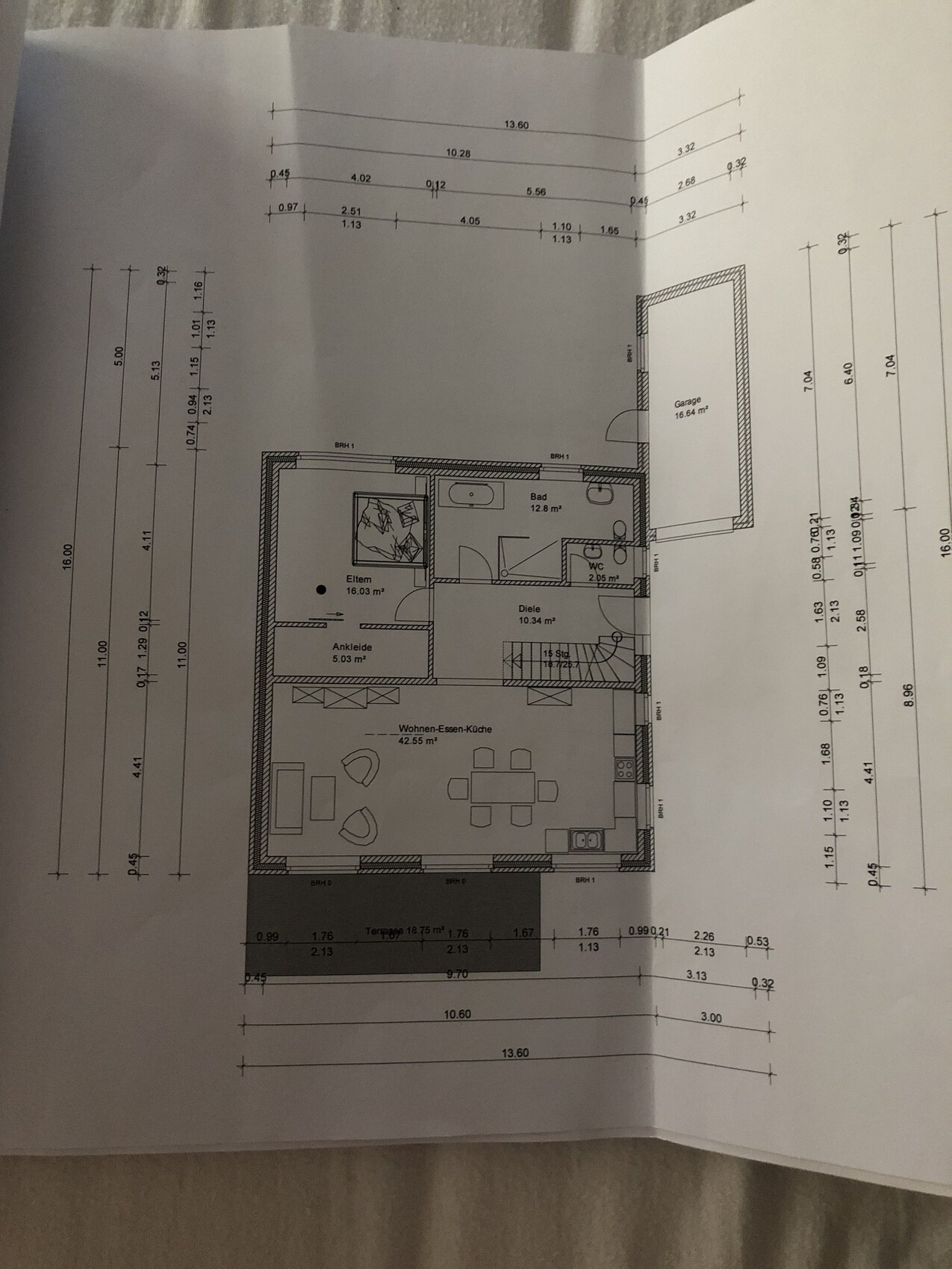 Grundriss eines Hauses: offener Wohn-/Ess-/Küchenbereich, Elternschlafzimmer, Ankleide, Bad, Garage.