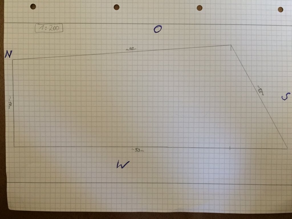 Handgezeichneter Grundrissplan auf Graphpapier mit Richtungen N S W