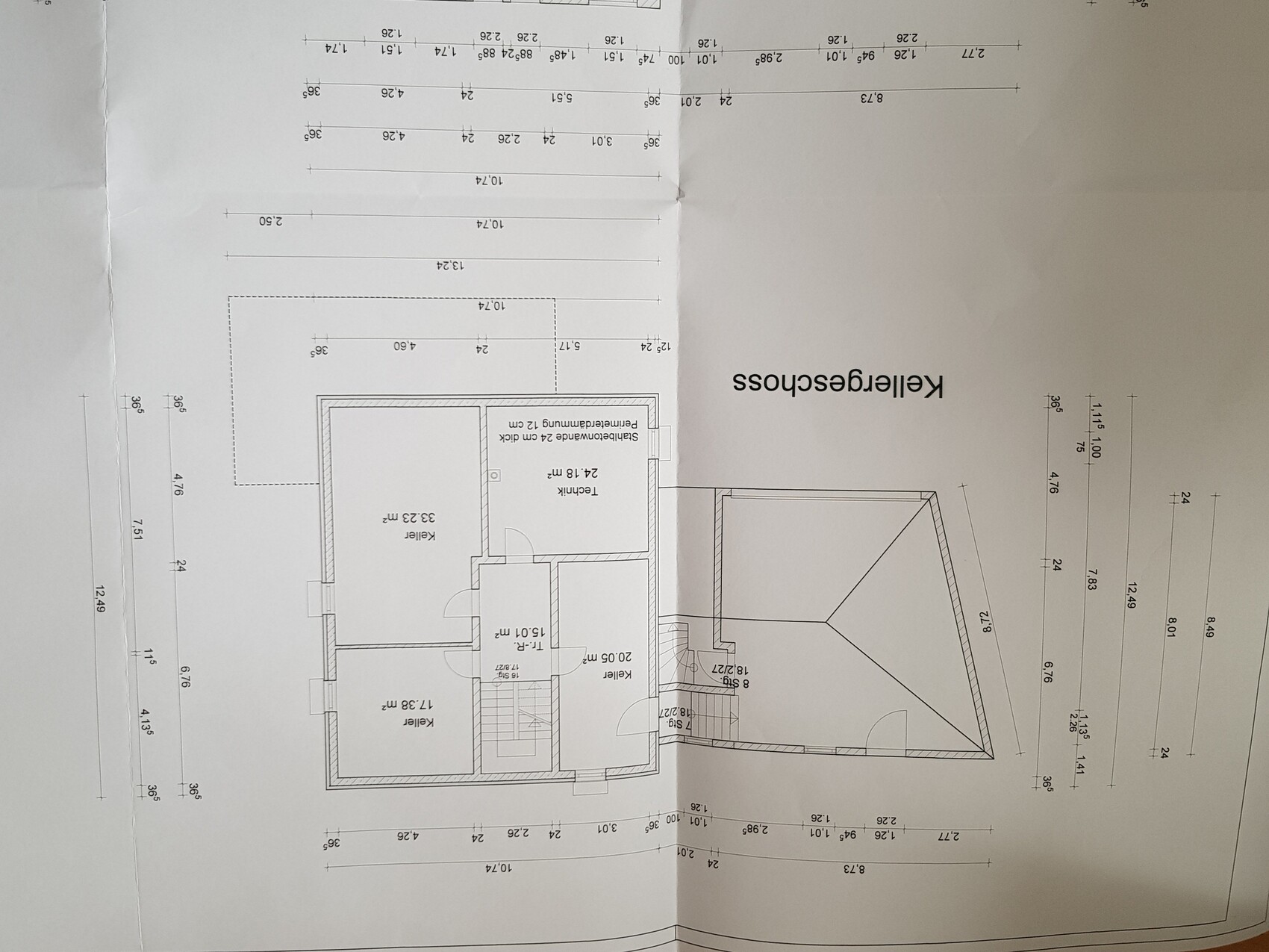 Kellergeschoss-Grundriss eines Hauses mit Kellerräumen, Treppe und Garage mit Satteldach.