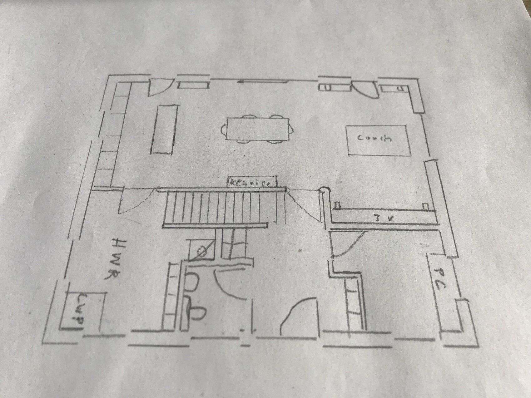 Handgezeichnete Grundriss-Skizze: Esstisch in der Mitte, Küche rechts, Treppe zentral.