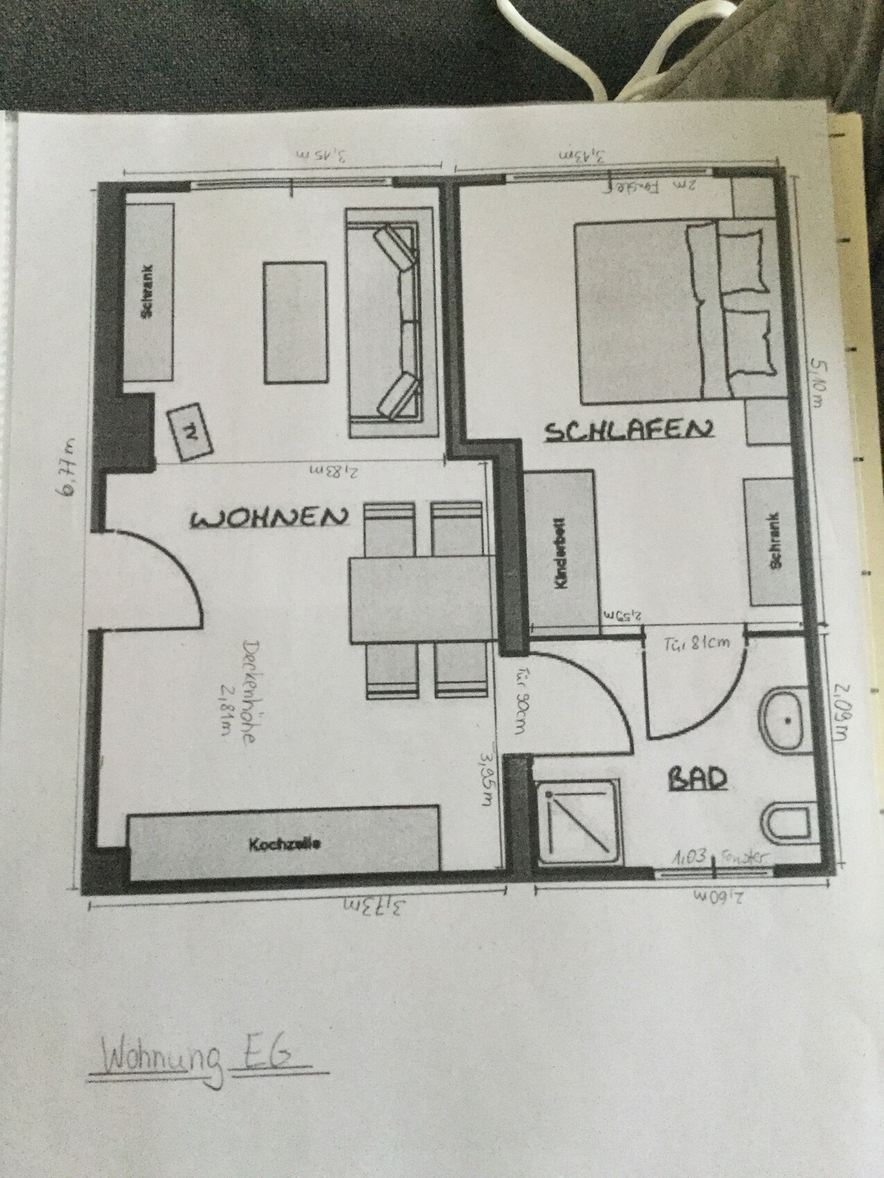 Grundriss einer Wohnung: links Wohnzimmer, unten Küche, rechts Schlafen, Bad unten rechts.