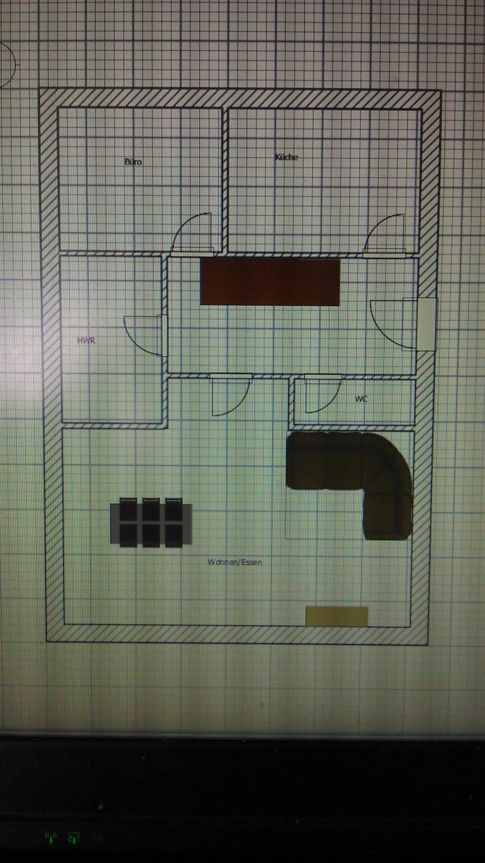Grundriss einer Wohnung: Büro, Küche, HWR, WC und Wohnbereich mit Esstisch und Sofa