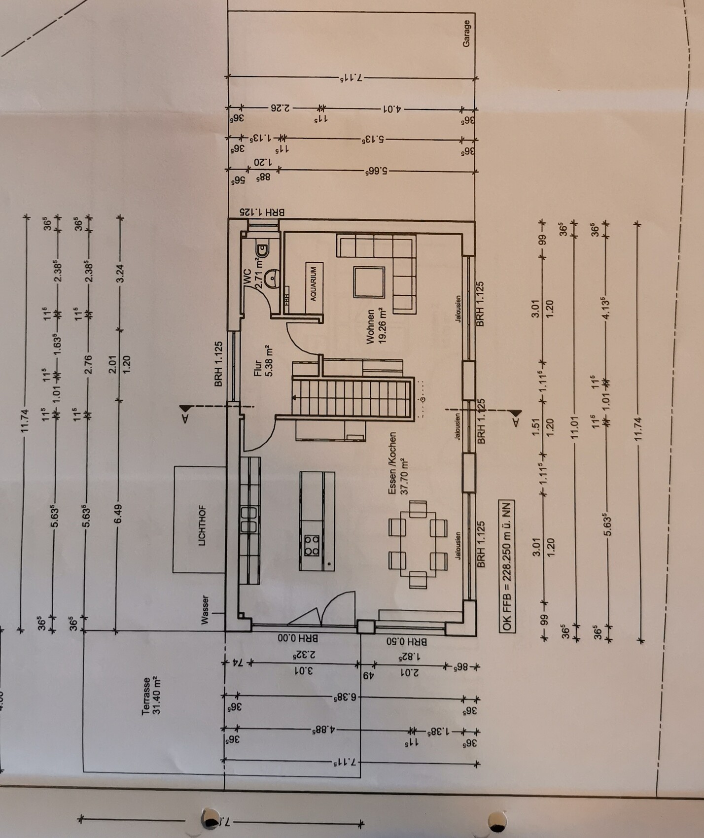 Grundriss eines Hauses: Wohnzimmer, Esse/Küche, Bad, Flur, Terrasse und Garage.