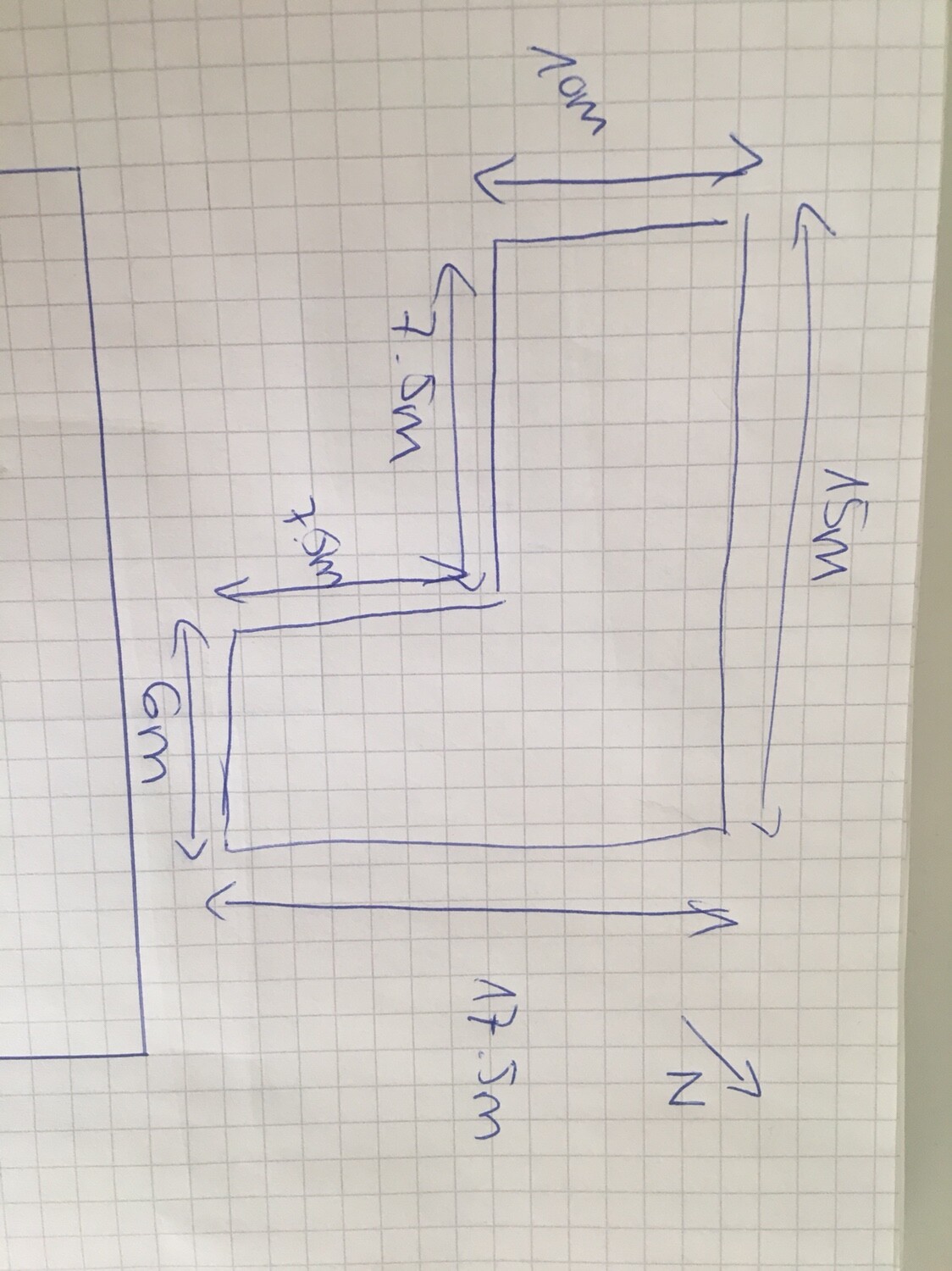 Handgezeichnete Grundrissskizze eines Gebäudes mit Maßangaben auf kariertem Papier