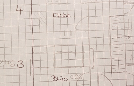 Skizze eines Grundrisses: Küche oben, Büro unten, auf kariertem Papier mit Türen und Möbeln.