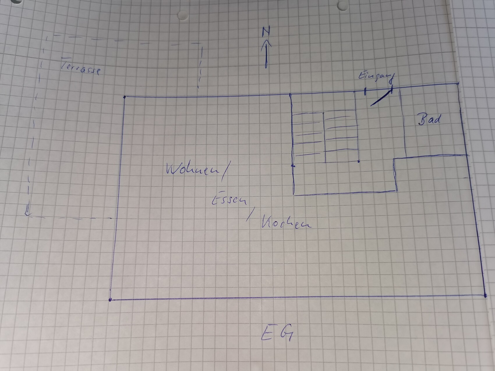 Handgezeichneter Grundriss: EG mit Wohn-/Essbereich, Bad, Eingang, Terrasse links; Norden.