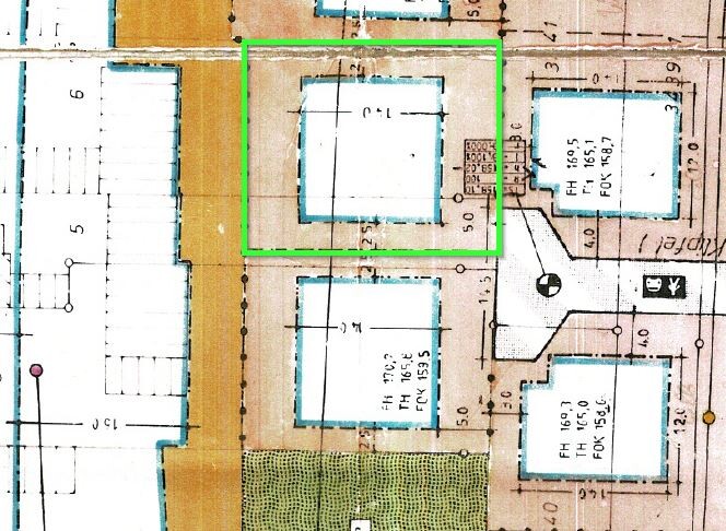 Architektonischer Grundriss eines Gebäudekomplexes; grün markiertes Innenareal im Zentrum.