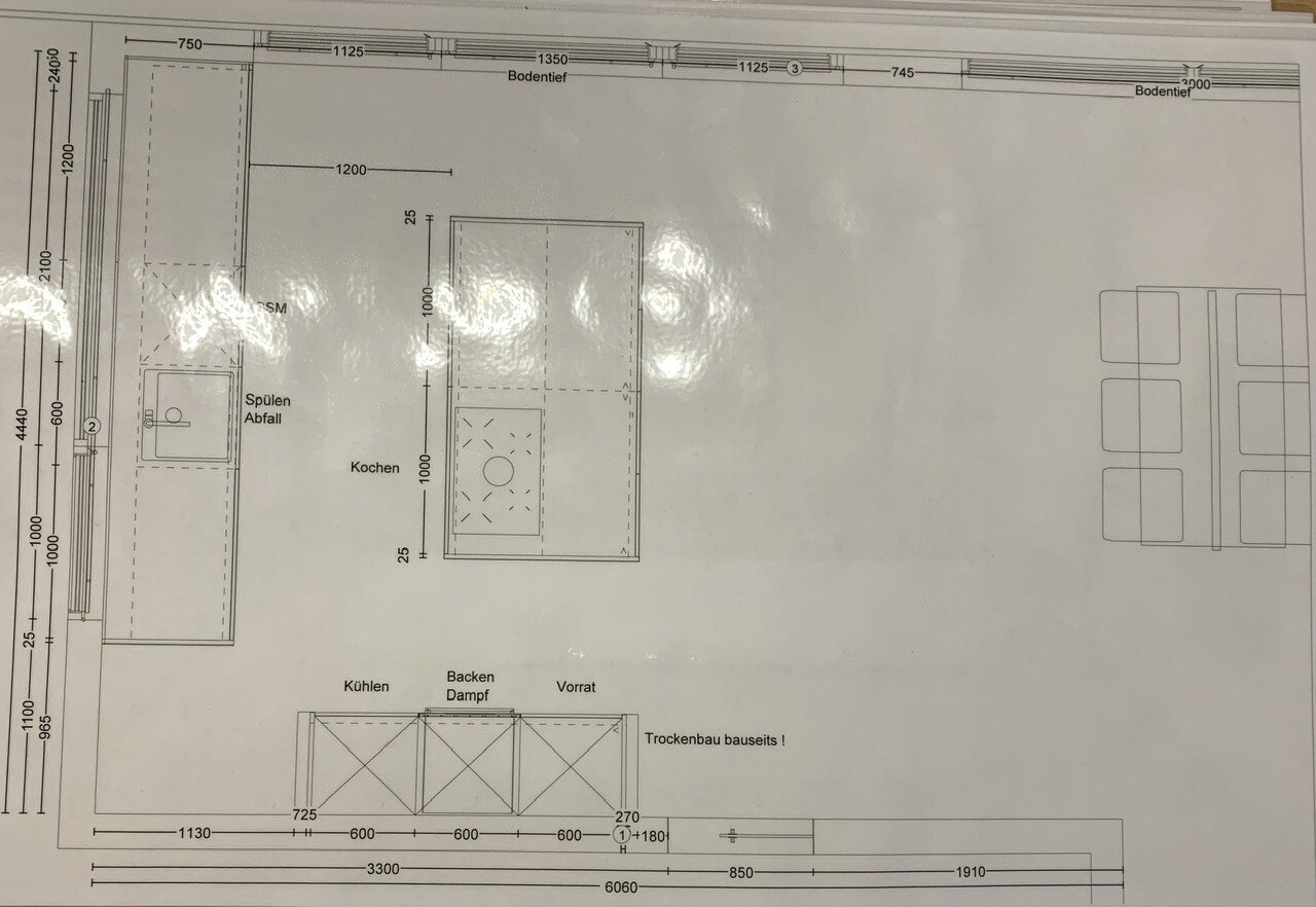 Grundriss einer Küche mit Spüle, Kochinsel, Abfall, Kühl-/Back-/Vorratsbereich und Essbereich rechts.