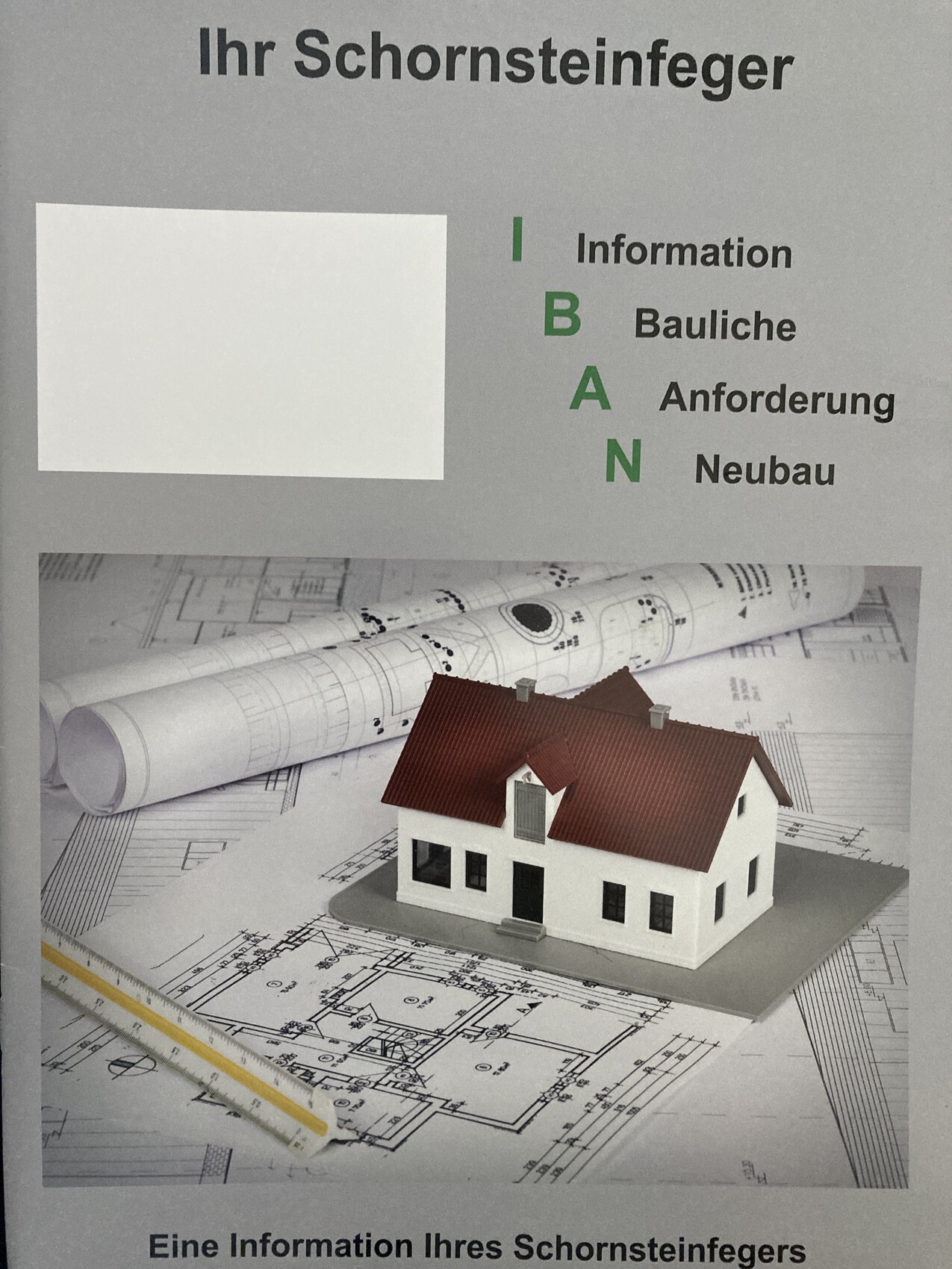 Miniaturhausmodell liegt auf Bauplänen und Blaupausen, Symbol für Hausbau-Planung