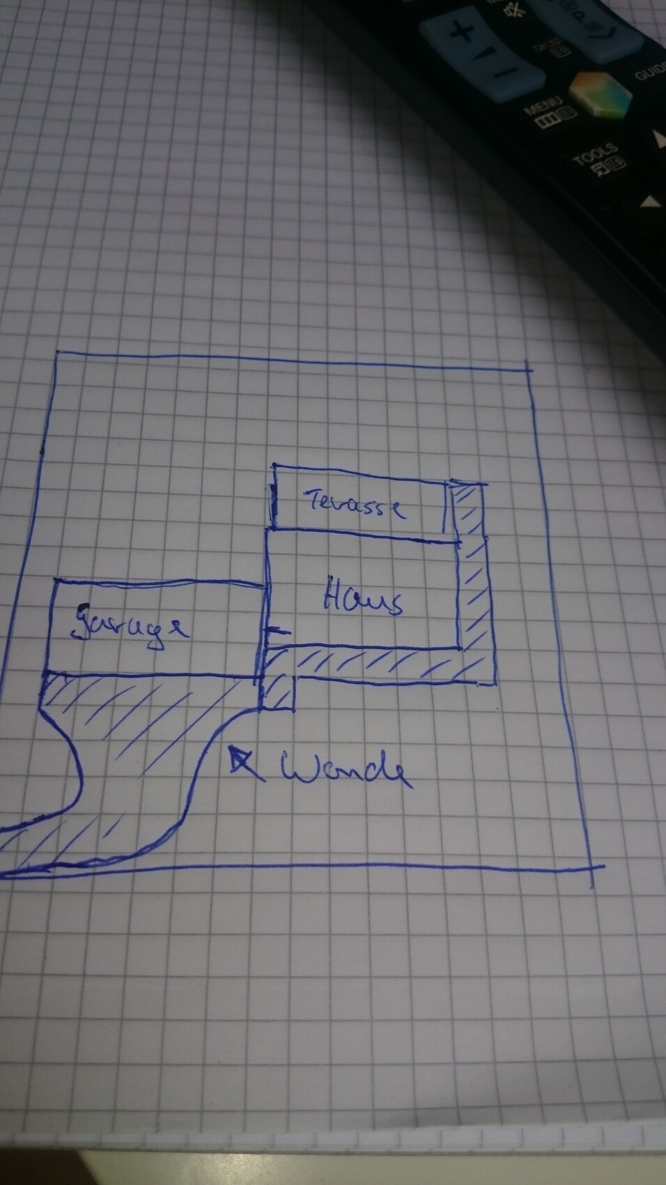 Skizzenhafter Grundrissplan mit Haus, Terrasse und Garage auf Gitterpapier