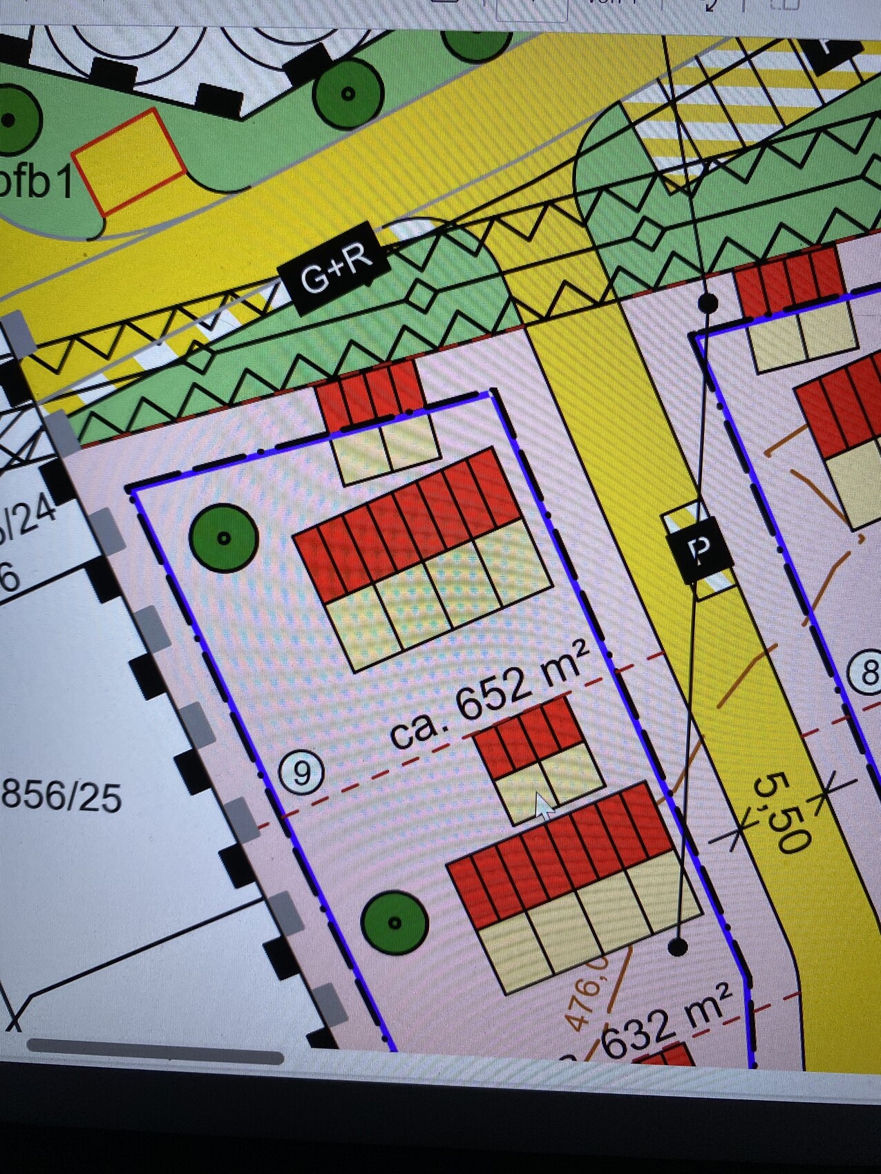 Lageplan eines Baugrundstücks mit roten Gebäuden, Grünflächen, gelber Straße und Maßen ca. 652 m²