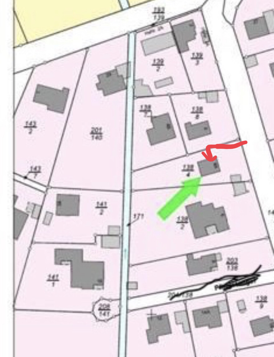 Lageplan eines Baugrundstücks mit Parzellen, Gebäuden und Pfeilen zur Orientierung