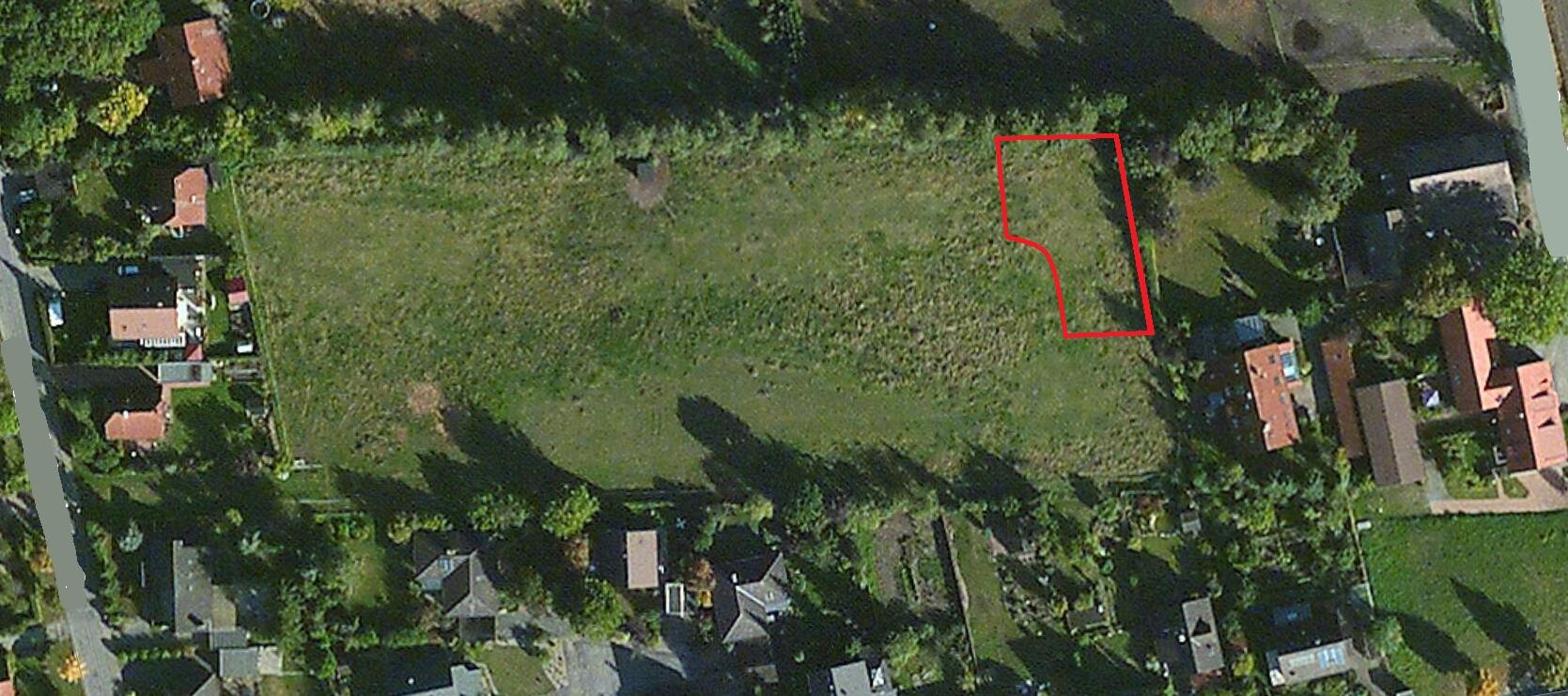 Luftbild eines Grundstücks mit rotem Umriss des geplanten Gebäudebereichs