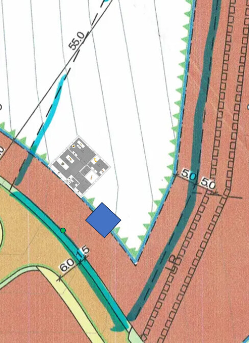 Lageplan mit blauem Marker auf rotem Gebiet, neben Wasserlauf und Gebäudefläche.