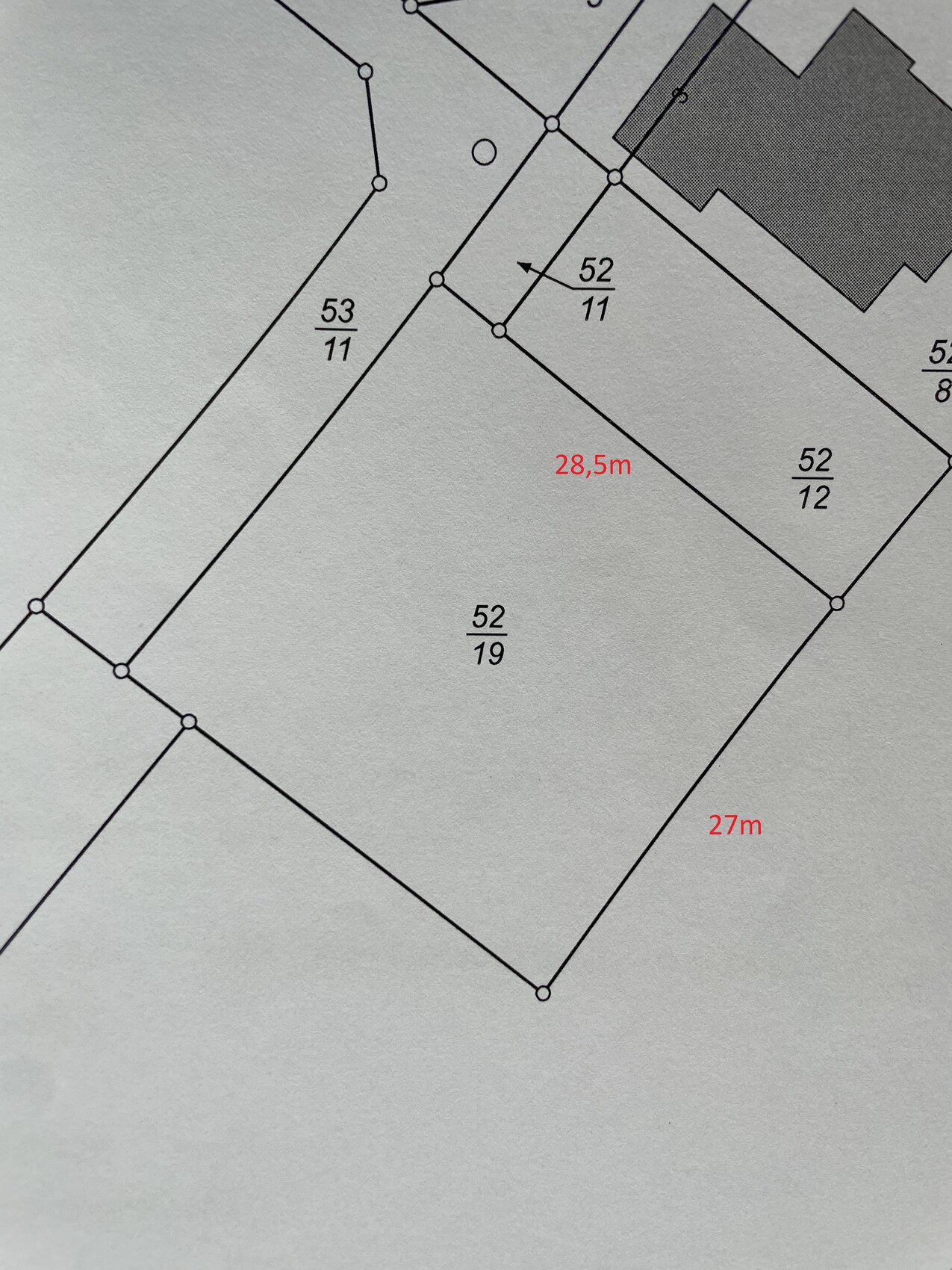 Lageplan: Parzellenlinien, Maße 28,5 m und 27 m, Gebäudeumriss rechts oben.