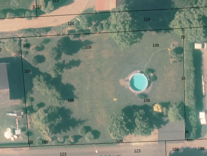 Satellitenbild eines Grundstücks: runder Pool im Garten, Bäume ringsum