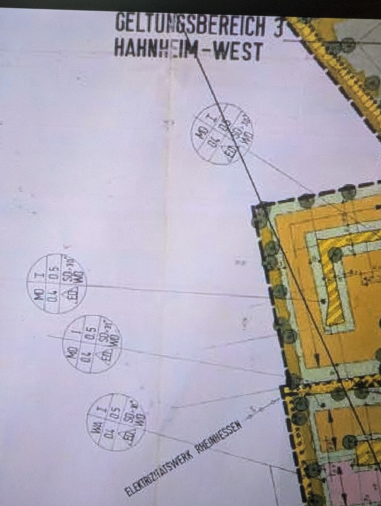 Architekturplan eines gelben Gebäudes mit Kreisen und Maßangaben am Bildrand.