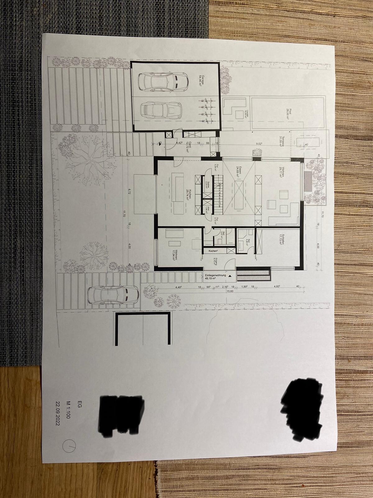 Grundriss eines Hauses mit Garage für zwei Autos, Eingangsbereich und Garten.