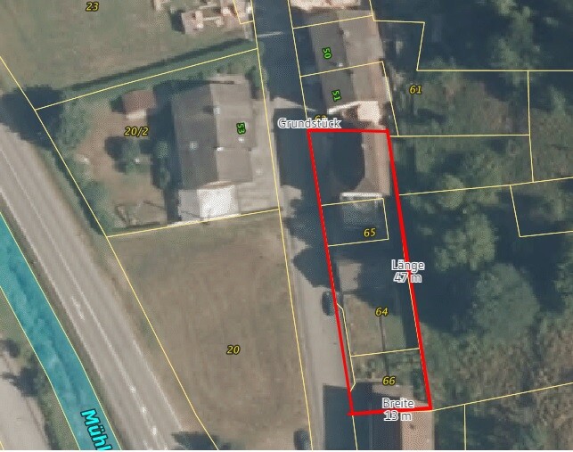 Langgestrecktes Grundstück mit roter Umrandung entlang einer Straße; Gebäude erkennbar.
