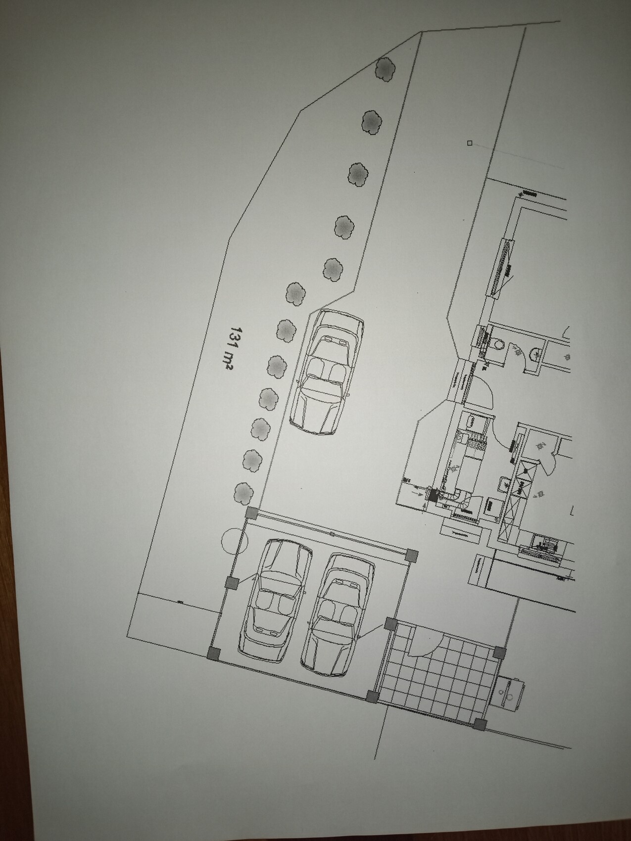 Lageplan eines Grundstücks mit Parkplätzen, Baumbepflanzung und Gebäudestruktur im Grundriss.