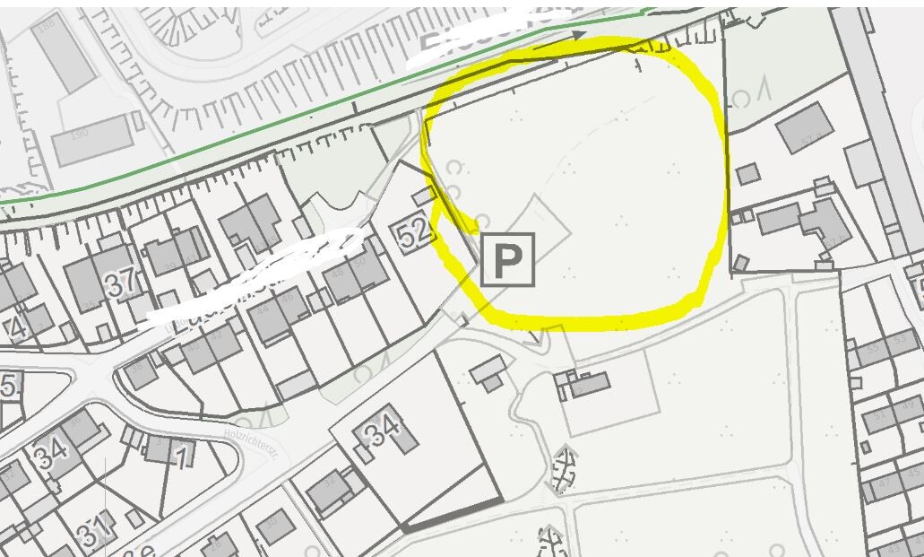 Schwarz-weiß-Stadtplan mit gelbem Kreis um den Parkplatzbereich (P) neben Gebäuden.