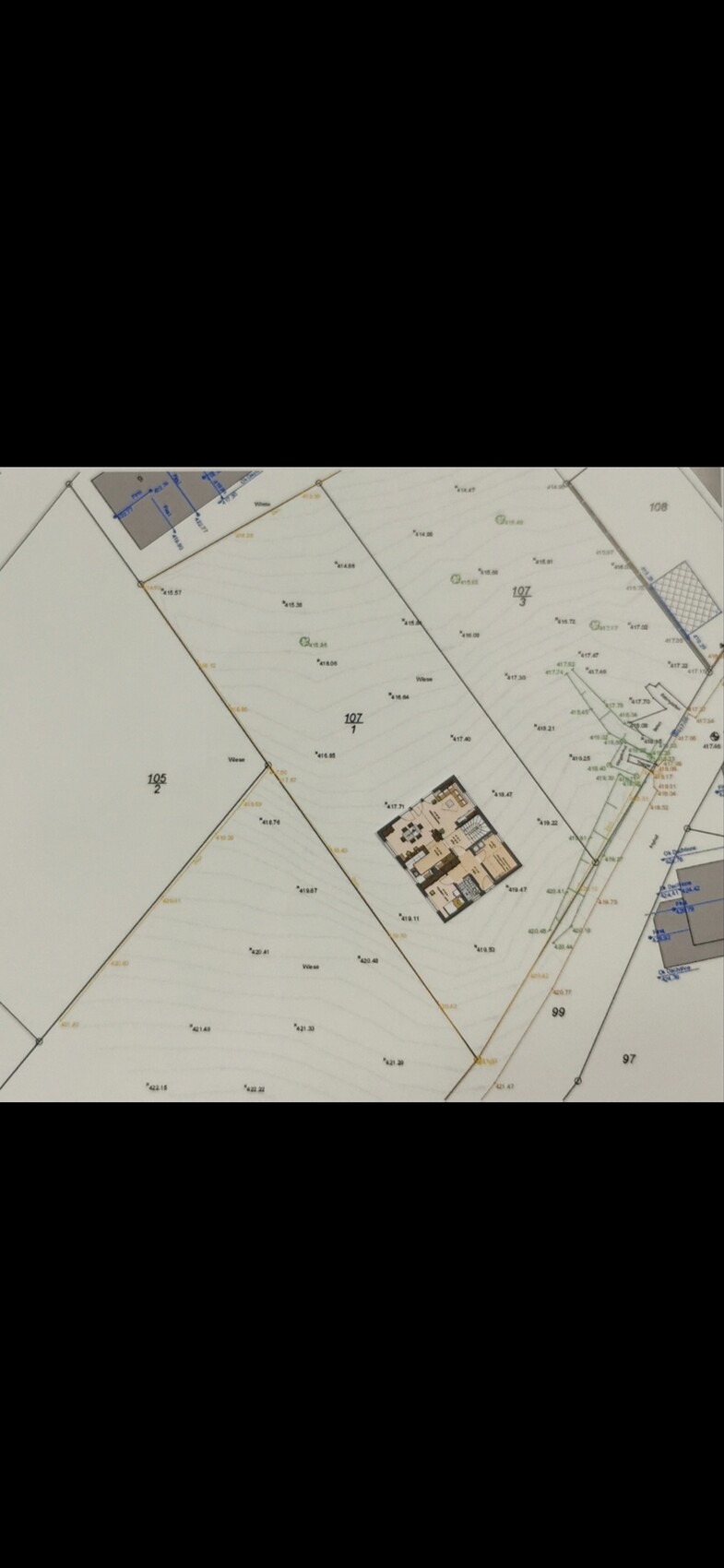 Lageplan eines Baugrundstücks mit Parzellen und zentralem Gebäude, Geländekonturen.