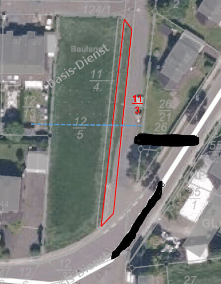 Luftbild eines Baugrundstücks mit roter Grundstücksgrenze und blauem Grenzverlauf