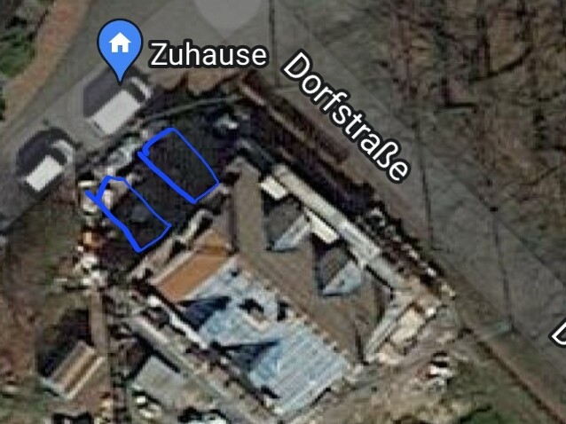Satellitenaufnahme eines Gebäudekomplexes an der Dorfstraße; zwei blau umrissene Flächen im Hof.