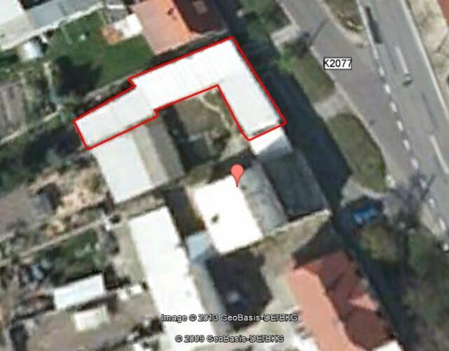 Luftaufnahme eines Gebäudekomplexes mit roter Umrandung des Grundstücks und Standortmarkierung