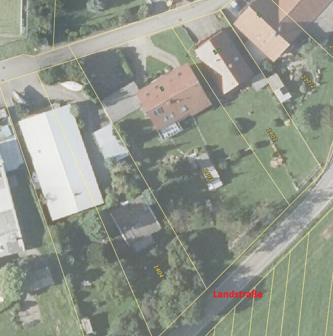 Aerial view of property parcels with yellow boundary lines and a road labeled Landstrasse