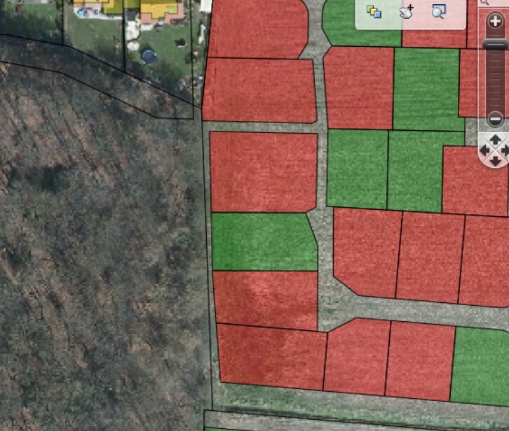 Luftbild eines Grundstücksplans mit rot/grünen Parzellen und Straßenverlauf