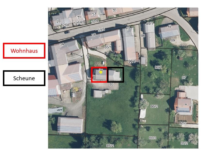Luftbild eines Grundstücks; roter Umriss markiert das Wohnhaus, schwarzer Umriss die Scheune.