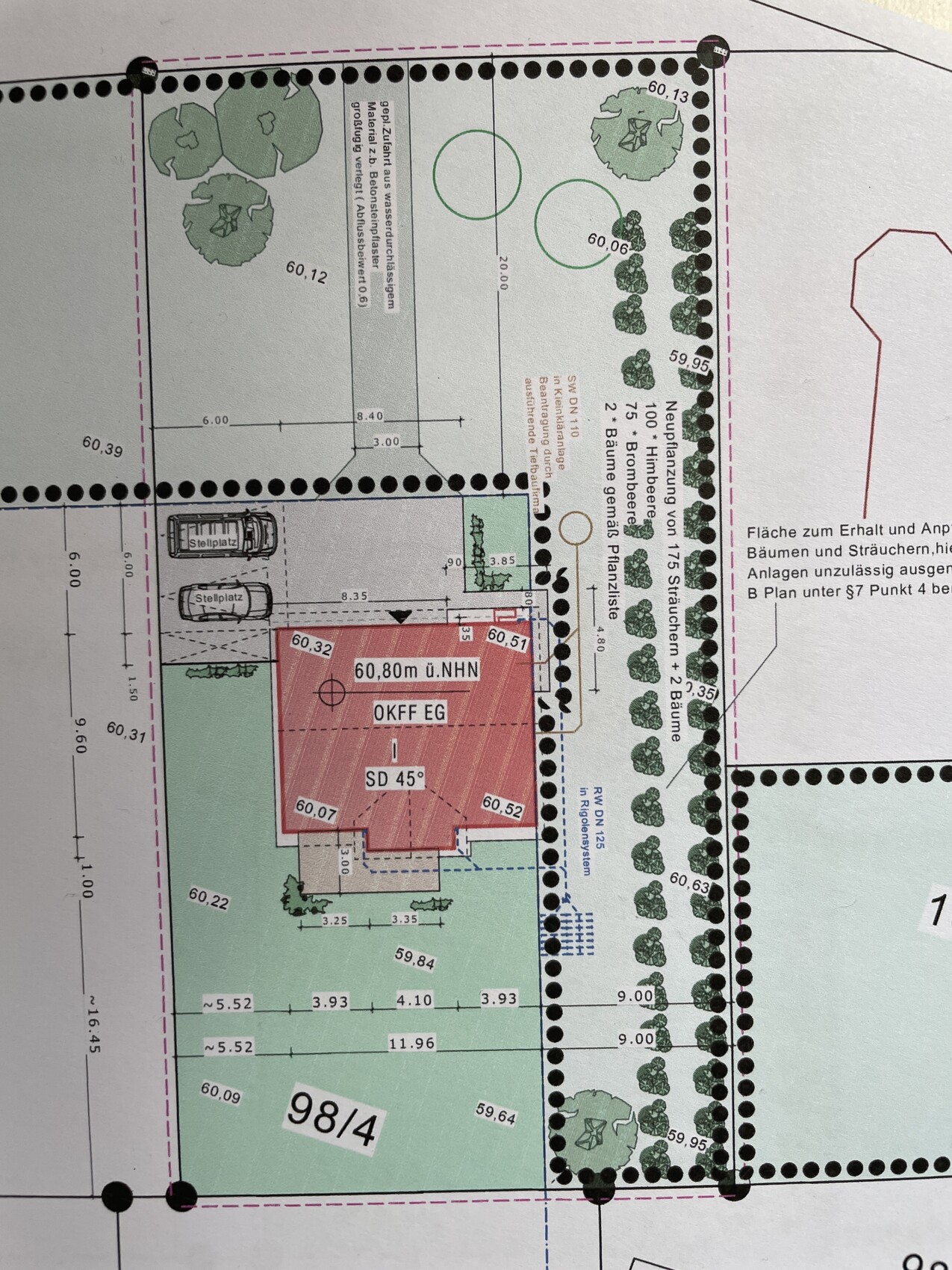 Lageplan eines Grundstücks: rotes Gebäudefläche, Parkplätze, Bäume und Grünflächen.