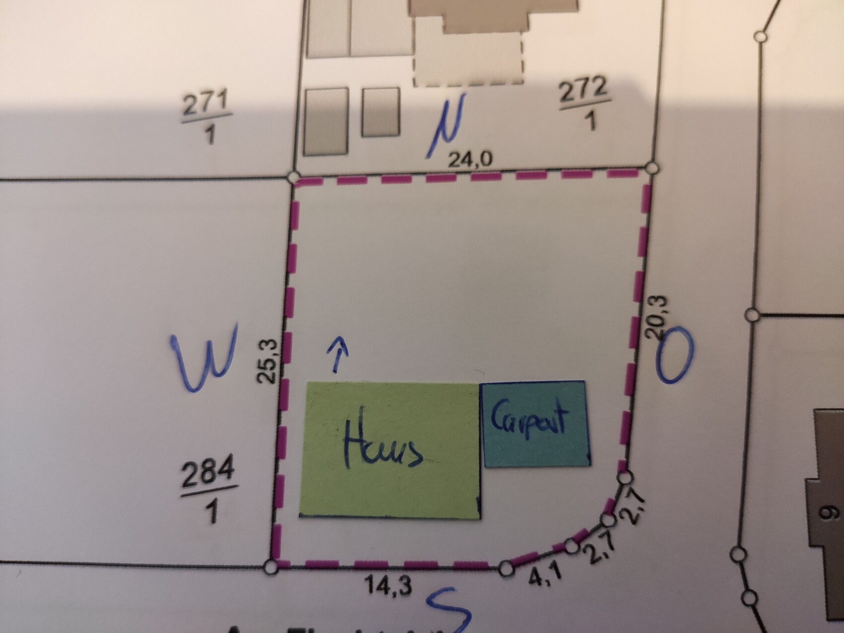 Grundriss eines Baugrundstücks: grünes Haus, blauer Carport, magentafarbene Grenzlinie.