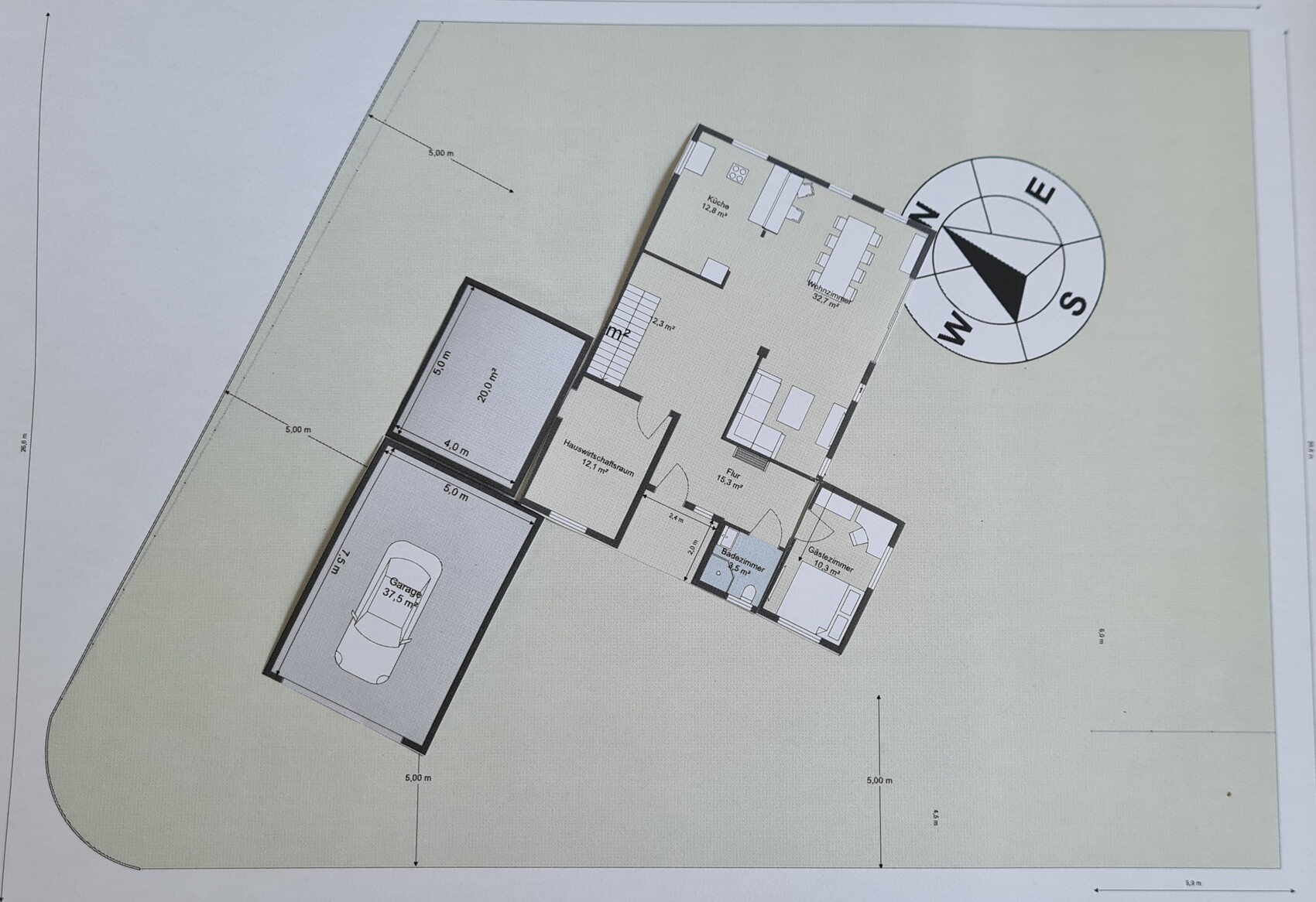 Grundriss eines Hauses mit Garage, Küche, Wohnzimmer, Flur, Bad und Gästezimmer; Kompassrose.