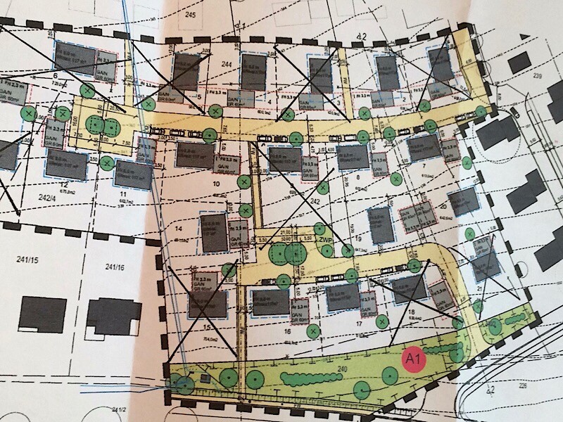 Übersichtlicher Baugrundstücksplan mit Straßen, Wegen, Gebäuden und Baumreihen im Gelände