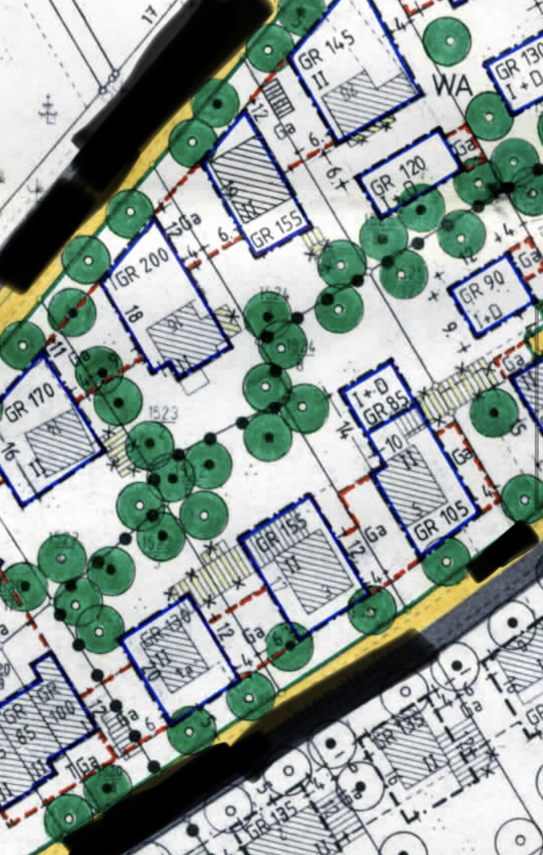 Lageplan eines Baugrundstücks mit grünen Bäumen und blau umrandeten Gebäudeflächen