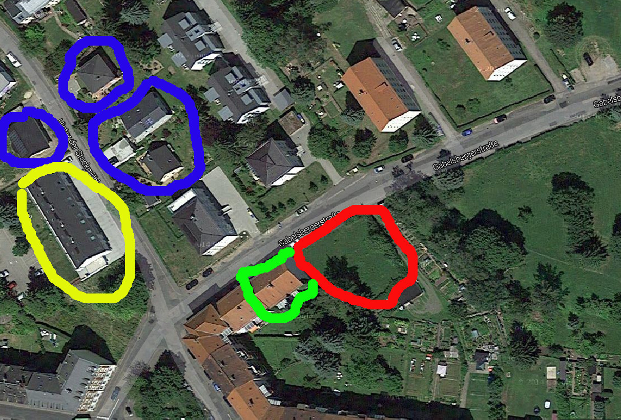 Luftbild eines Wohnquartiers mit markierten Grundstücken in Gelb, Blau, Grün und Rot