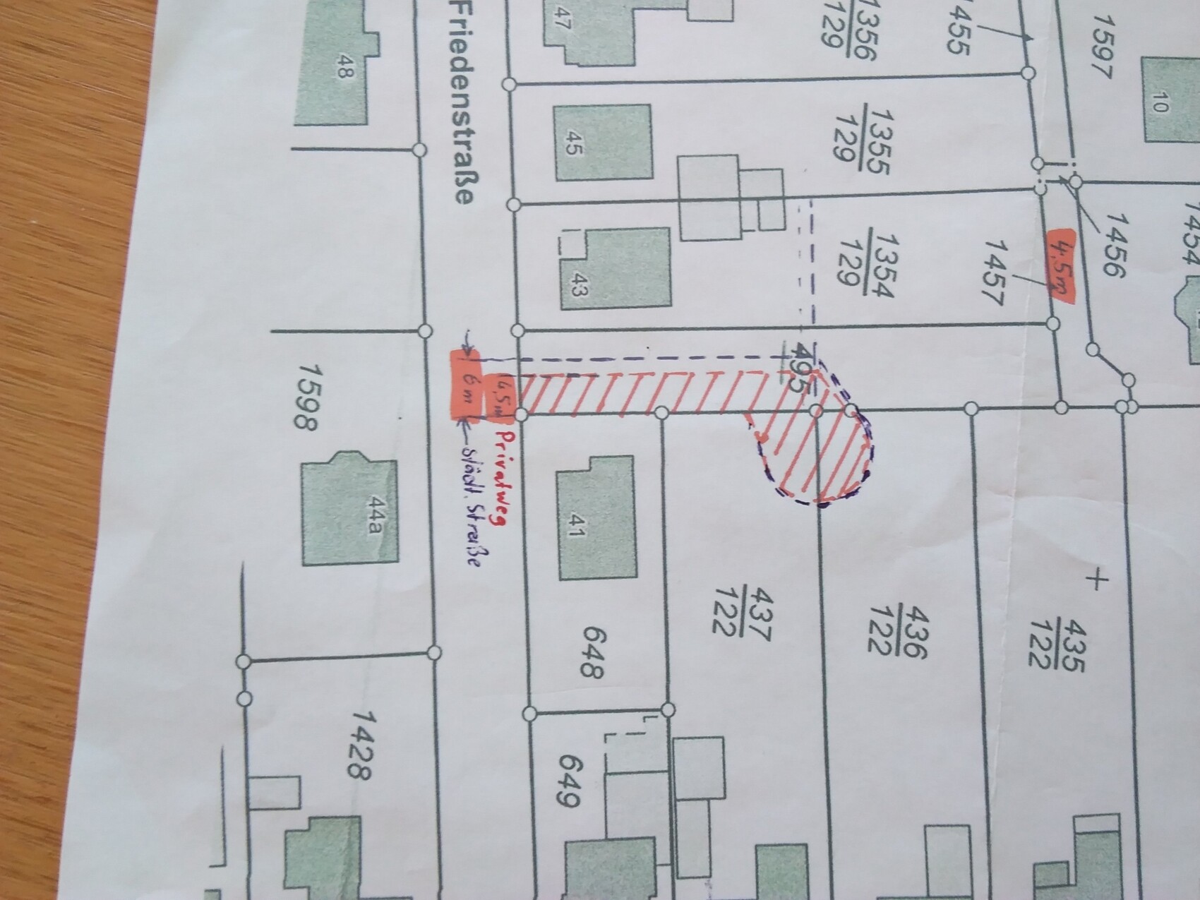 Lageplan mit Parzellen, Straßennamen und rot schraffierter Bauzone
