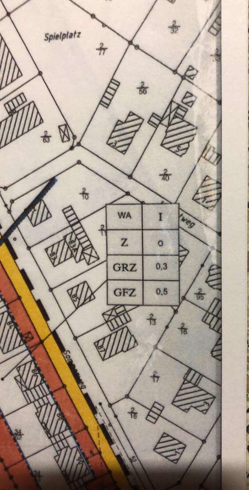 Detaillierter Bebauungsplan: Parzellen, Gebäude, Straßen; Spielplatz und Zonenwerte WA, GRZ, GFZ.