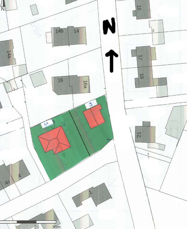 Lageplan: Zwei rote Gebäude auf grünem Grundstück, von Straßen umgeben, Nordausrichtung oben.