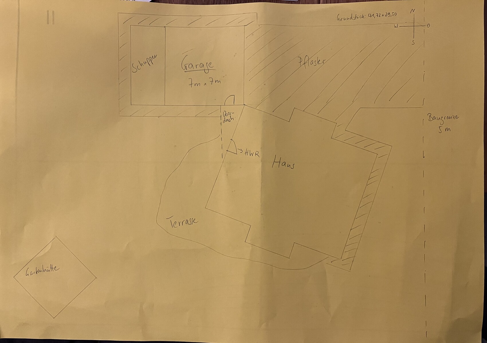 Skizze eines Baugrundstücks mit Haus, Garage, Terrasse und Gartenhütte