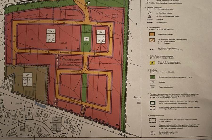 Lageplan eines Baugebiets mit farblich markierten Flächen, Straßennetz und Legende.