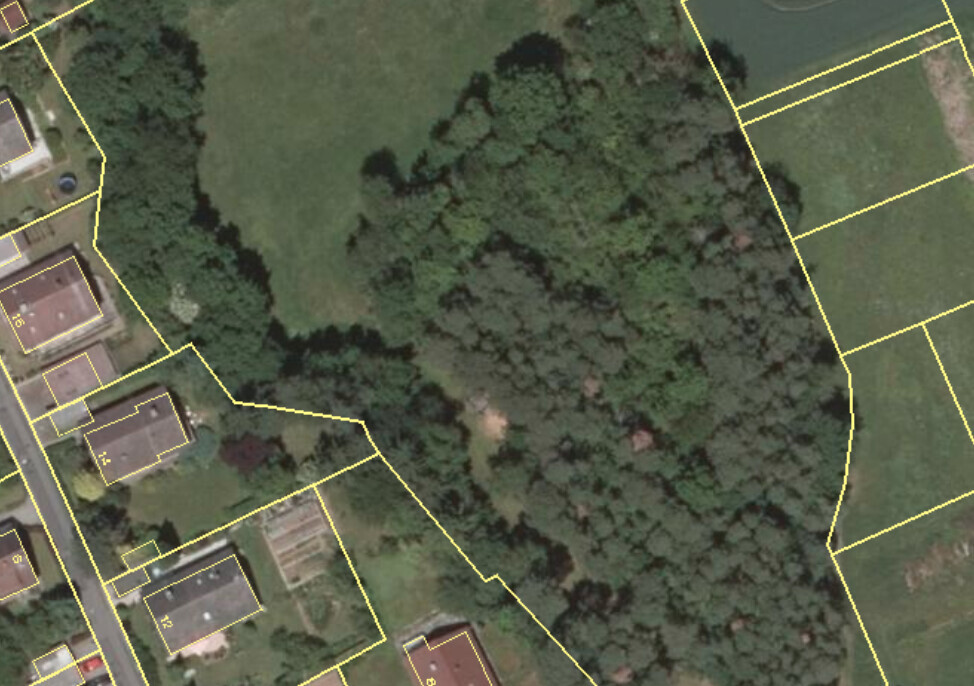 Luftbild einer Siedlung mit gelb markierten Grundstücksgrenzen und Waldfläche