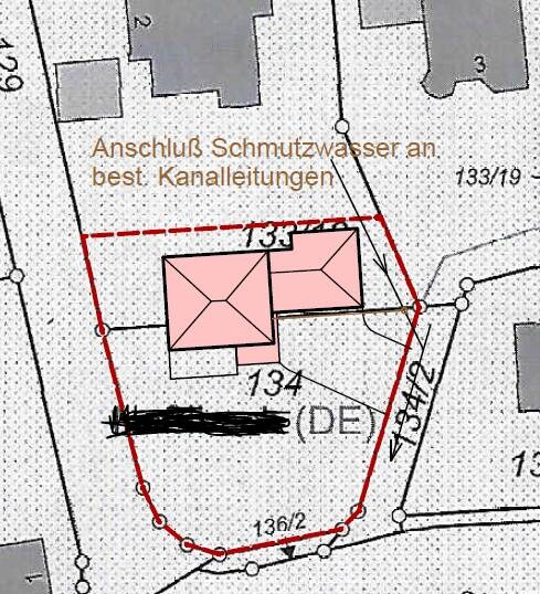 Lageplan eines Grundstücks mit zwei Gebäuden, rotem Umriss und Schmutzwasseranschluss.
