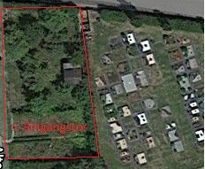 Luftbild eines Baugrundstücks mit roter Umrandung und Eingangstor
